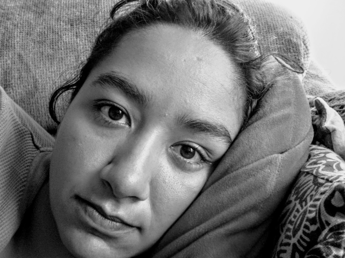 Close-up black and white shot of the author's face while lying on a couch